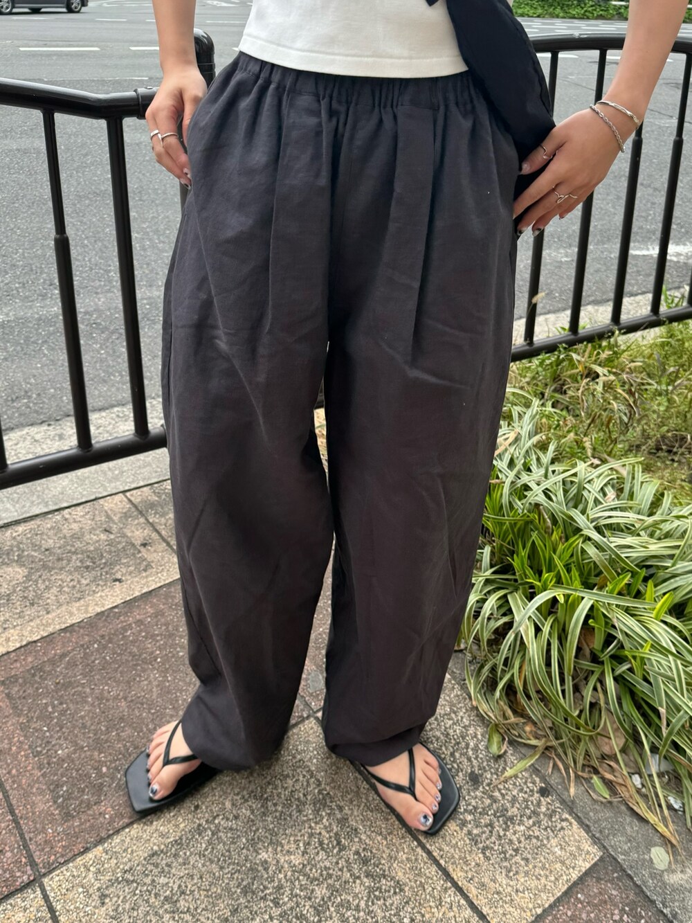 ホワイト系のTシャツ/カットソー、グレー系のその他パンツ、ブラック系のサンダルを着用したレディースの春コーディネートの10枚目の写真