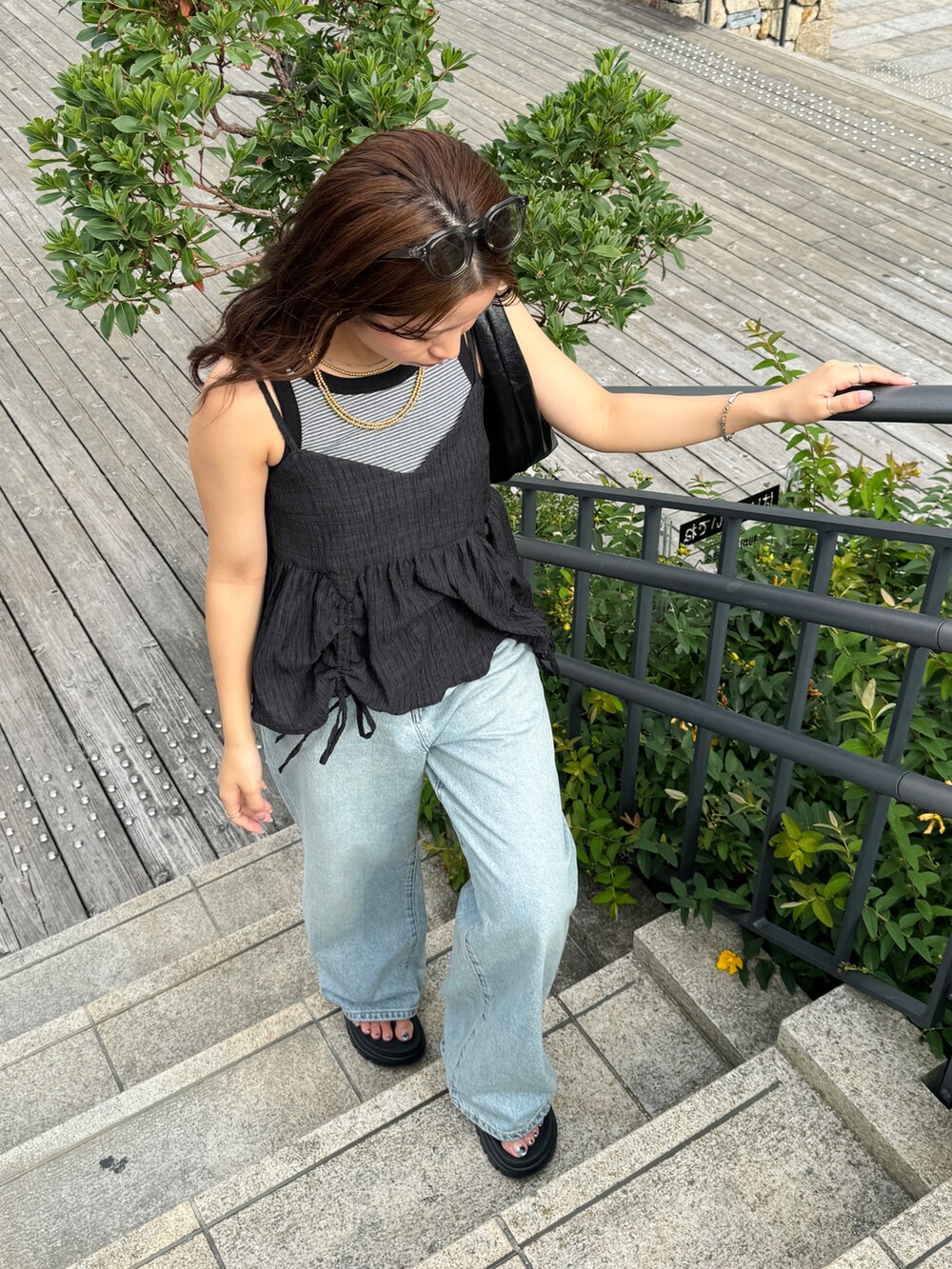 グレー系のタンクトップ、ブラック系のシャツ/ブラウス、ブルー系のデニムパンツを着用したレディースの夏コーディネートの6枚目の写真