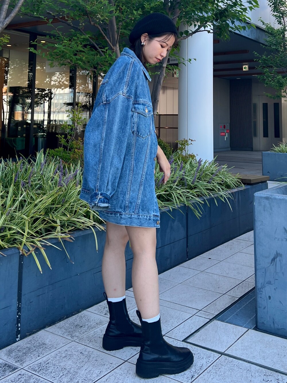 ブルー系のスウェット、ブルー系のデニムジャケット、ブラック系のハンチング/ベレー帽を着用したレディースの秋コーディネートの2枚目の写真