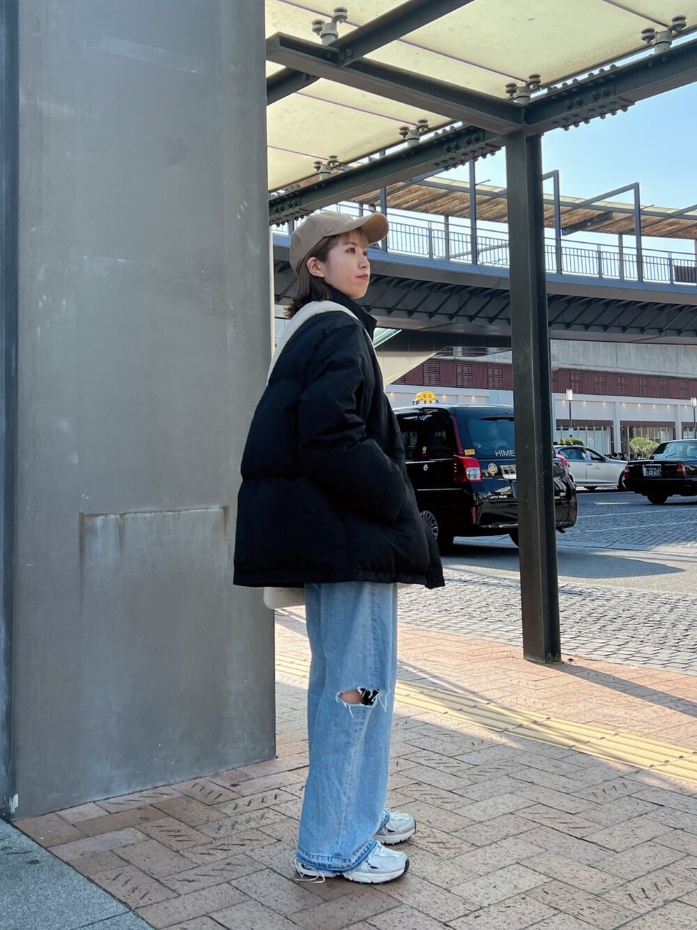 ブラック系のダウンジャケット/コート、ホワイト系のショルダーバッグ、ブルー系のデニムパンツを着用したレディースの秋コーディネートの6枚目の写真