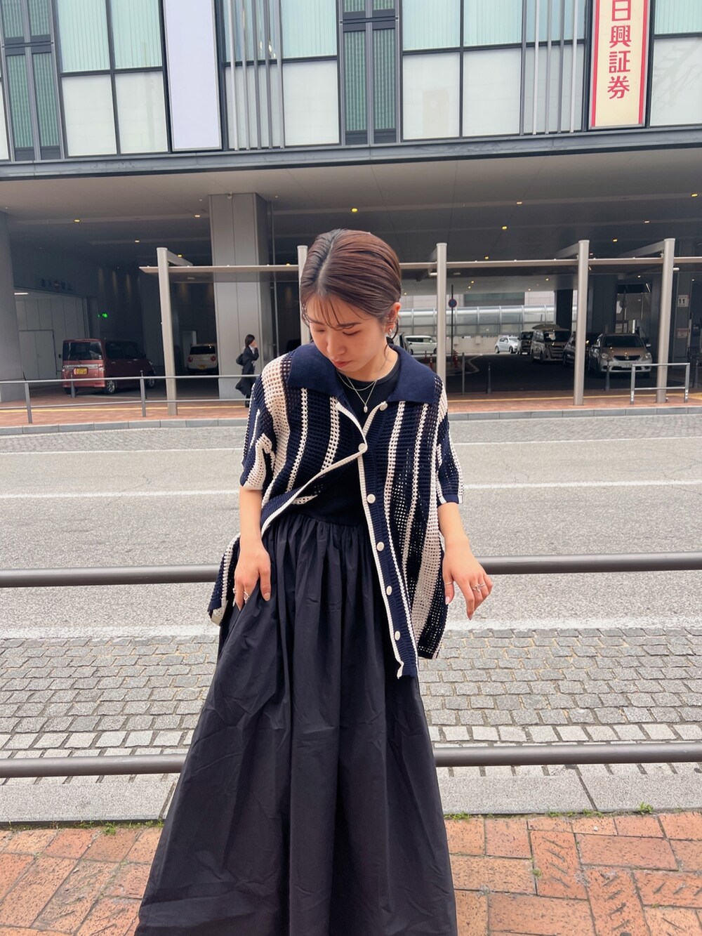 ブラック系のワンピース、ブルー系のカーディガン/ボレロ、ブラック系のサンダルを着用したレディースの春コーディネートの9枚目の写真