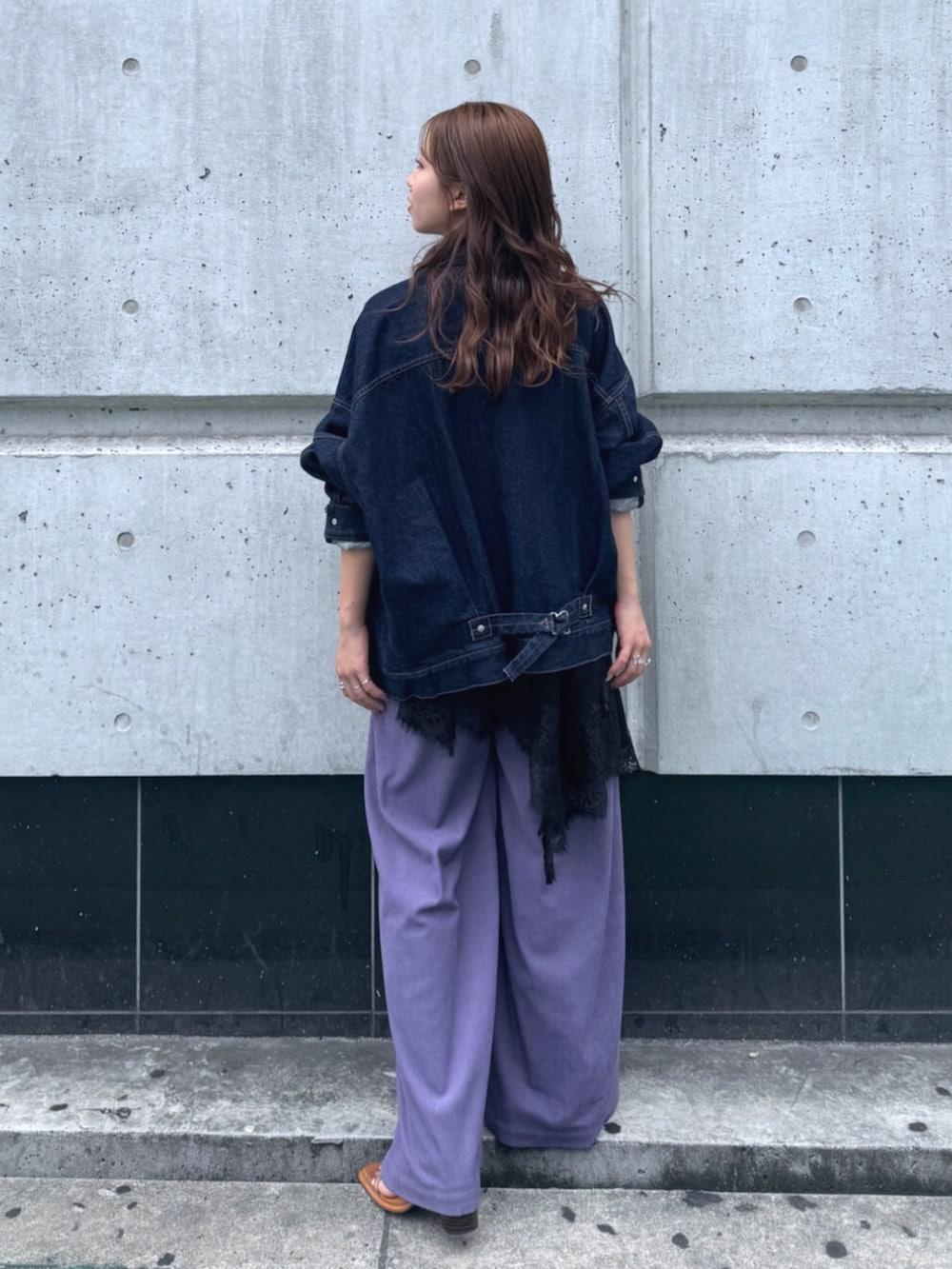 ブルー系のデニムジャケット、ブラック系のワンピース、パープル系のその他パンツを着用したレディースの夏コーディネートの3枚目の写真