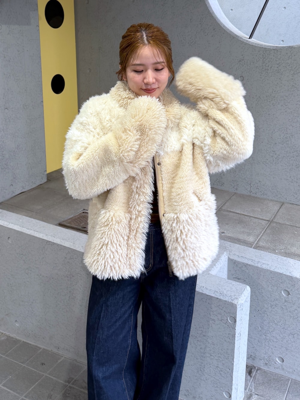 ホワイト系のブルゾン、シルバー系のパンプス、ブルー系のデニムパンツを着用したレディースの秋コーディネートの9枚目の写真