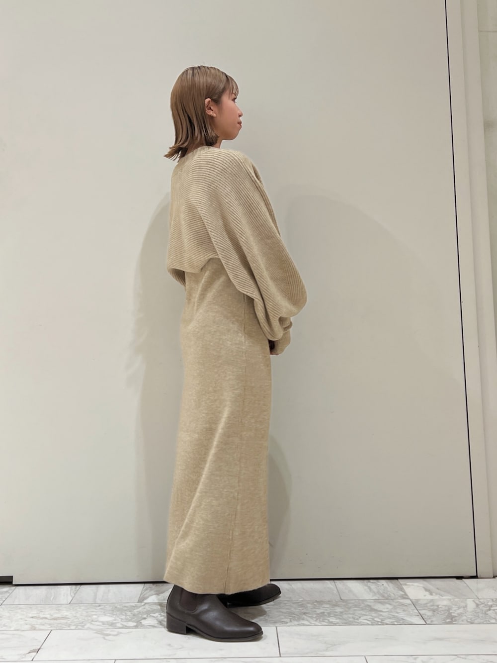 グレー系のワンピース、ブラウン系のブーツを着用したレディースの秋コーディネートの5枚目の写真