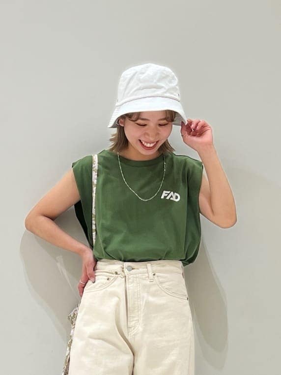 ホワイト系のデニムパンツ、グリーン系のタンクトップ、ホワイト系のハットを着用したレディースの春コーディネートの4枚目の写真