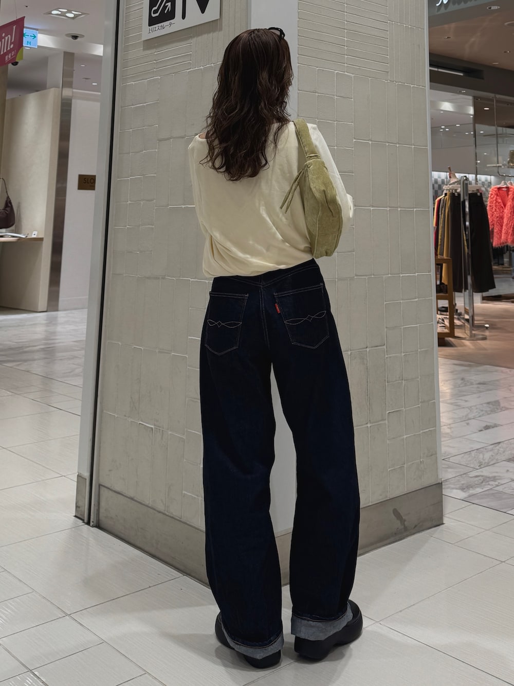 ブルー系のデニムパンツ、ホワイト系のTシャツ/カットソー、グリーン系のハンドバッグを着用したレディースの冬コーディネートの5枚目の写真