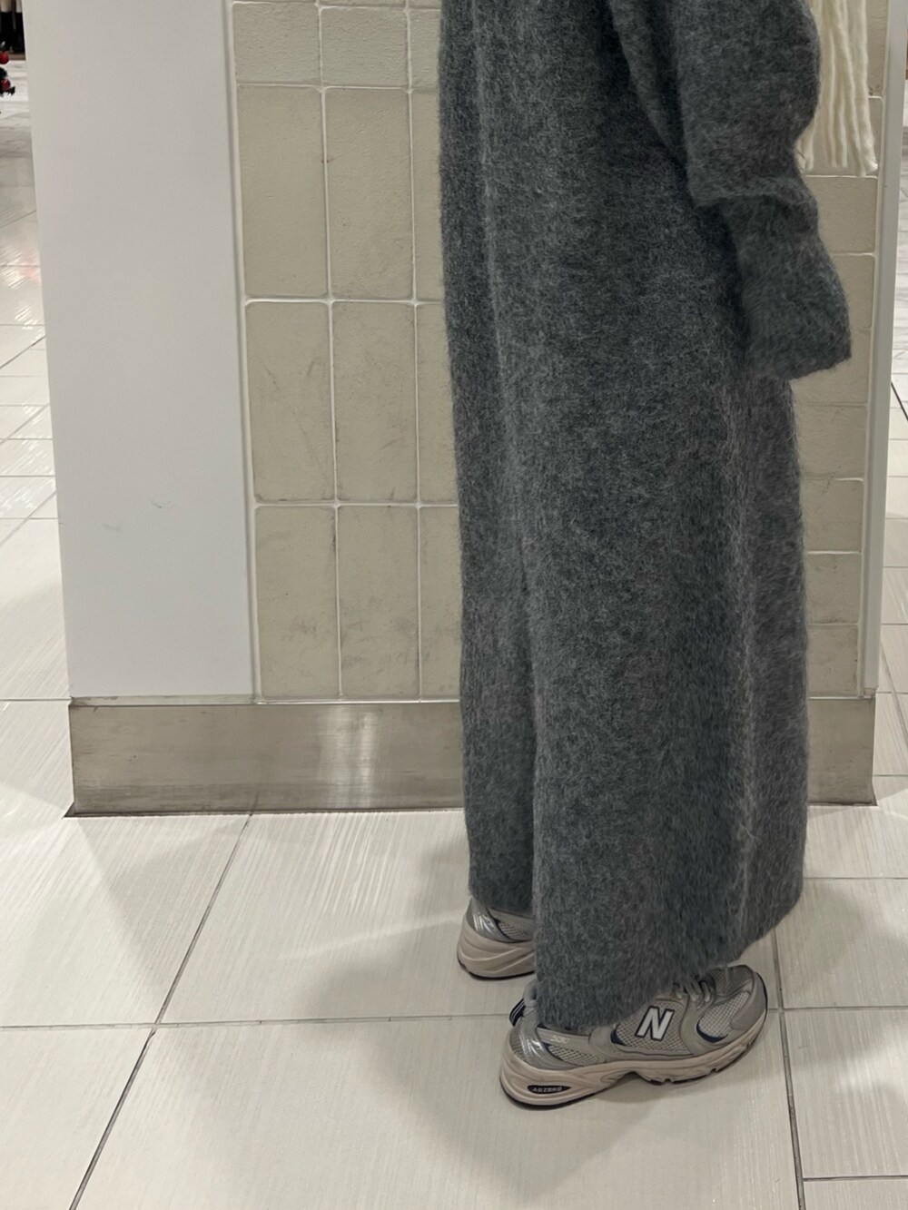 グレー系のワンピース、グリーン系のショルダーバッグ、ホワイト系のマフラーを着用したレディースの秋コーディネートの9枚目の写真