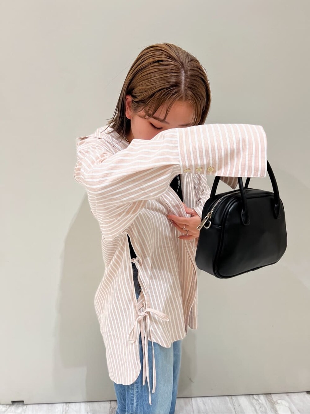 ブラック系のサンダル、ピンク系のシャツ/ブラウス、ブラック系のハンドバッグを着用したレディースの春コーディネートの9枚目の写真