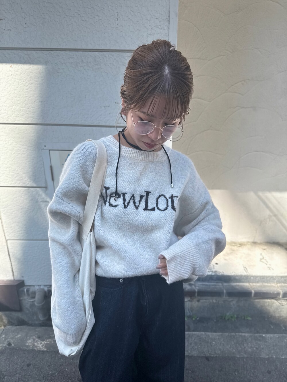 ブルー系のデニムパンツ、ホワイト系のニット/セーター、ホワイト系のトートバッグを着用したレディースの夏コーディネートの10枚目の写真