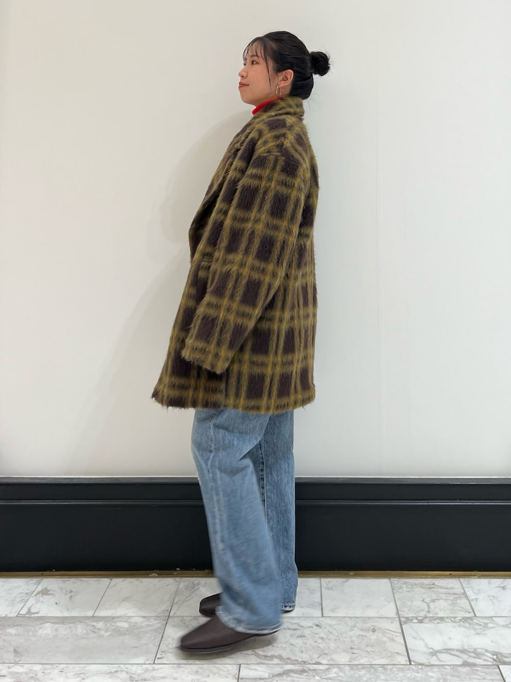 レッド系のニット/セーター、ホワイト系のハンドバッグ、ブルー系のデニムパンツを着用したレディースの冬コーディネートの6枚目の写真