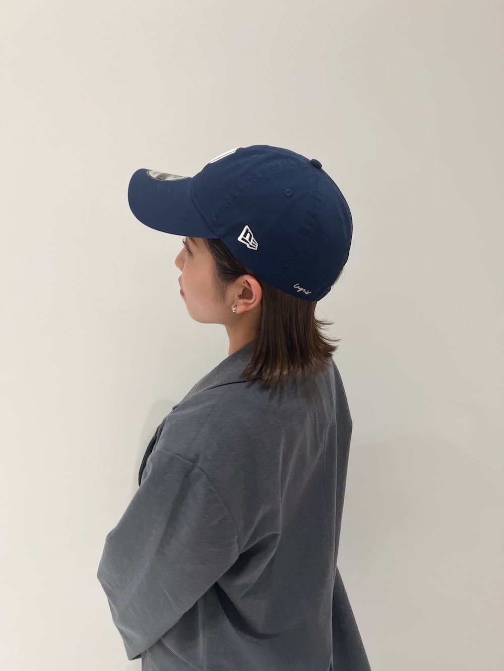 グレー系のテーラードジャケット、ブルー系のデニムパンツ、ブラック系のパンプスを着用したレディースの冬コーディネートの9枚目の写真