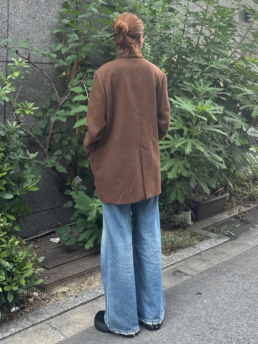 ブラウン系のテーラードジャケット、ブルー系のデニムパンツを着用したレディースの秋コーディネートの4枚目の写真