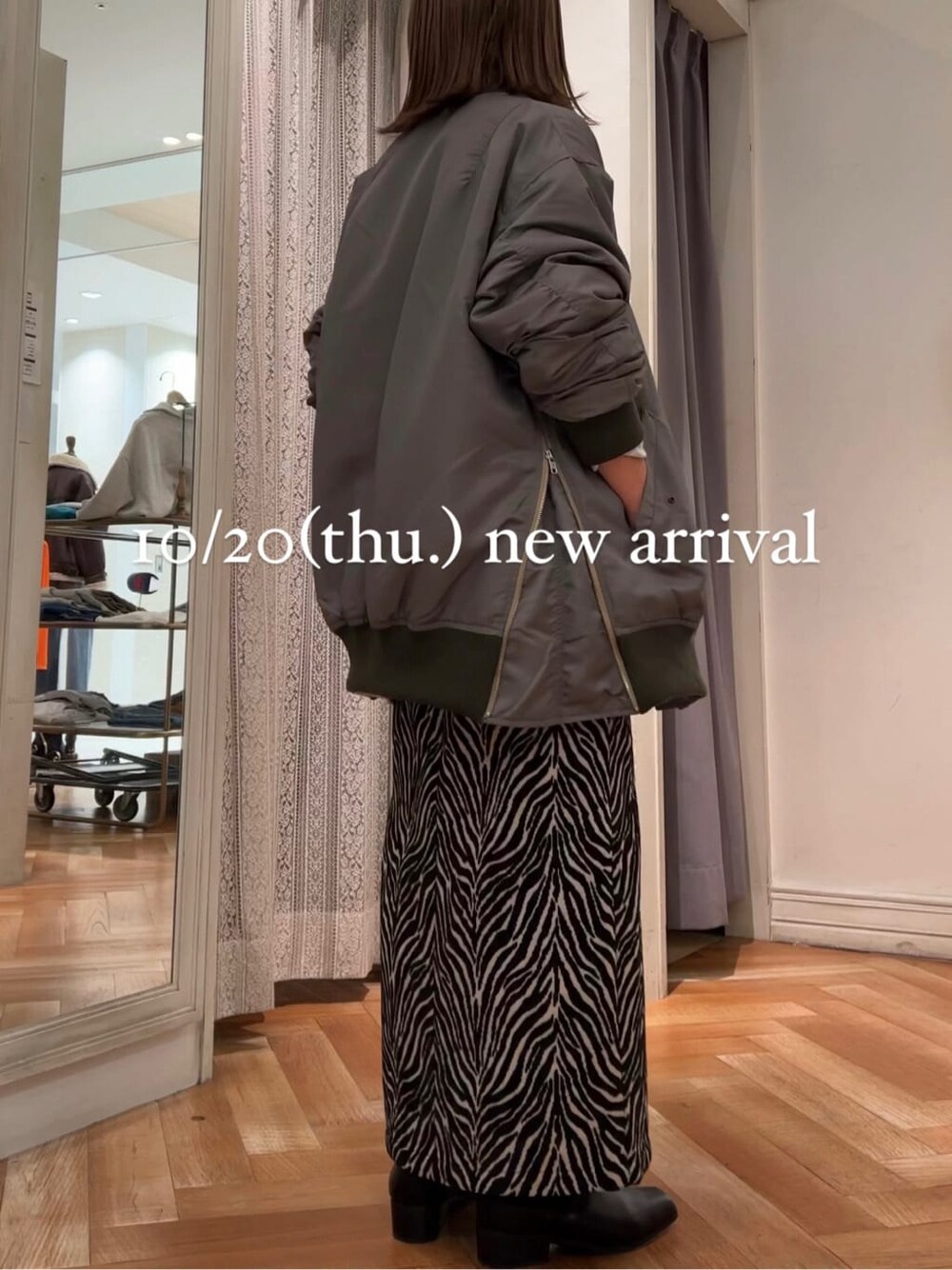 グレー系のスウェット、グリーン系のMA-1、ブラック系のスカートを着用したレディースの秋コーディネートの3枚目の写真