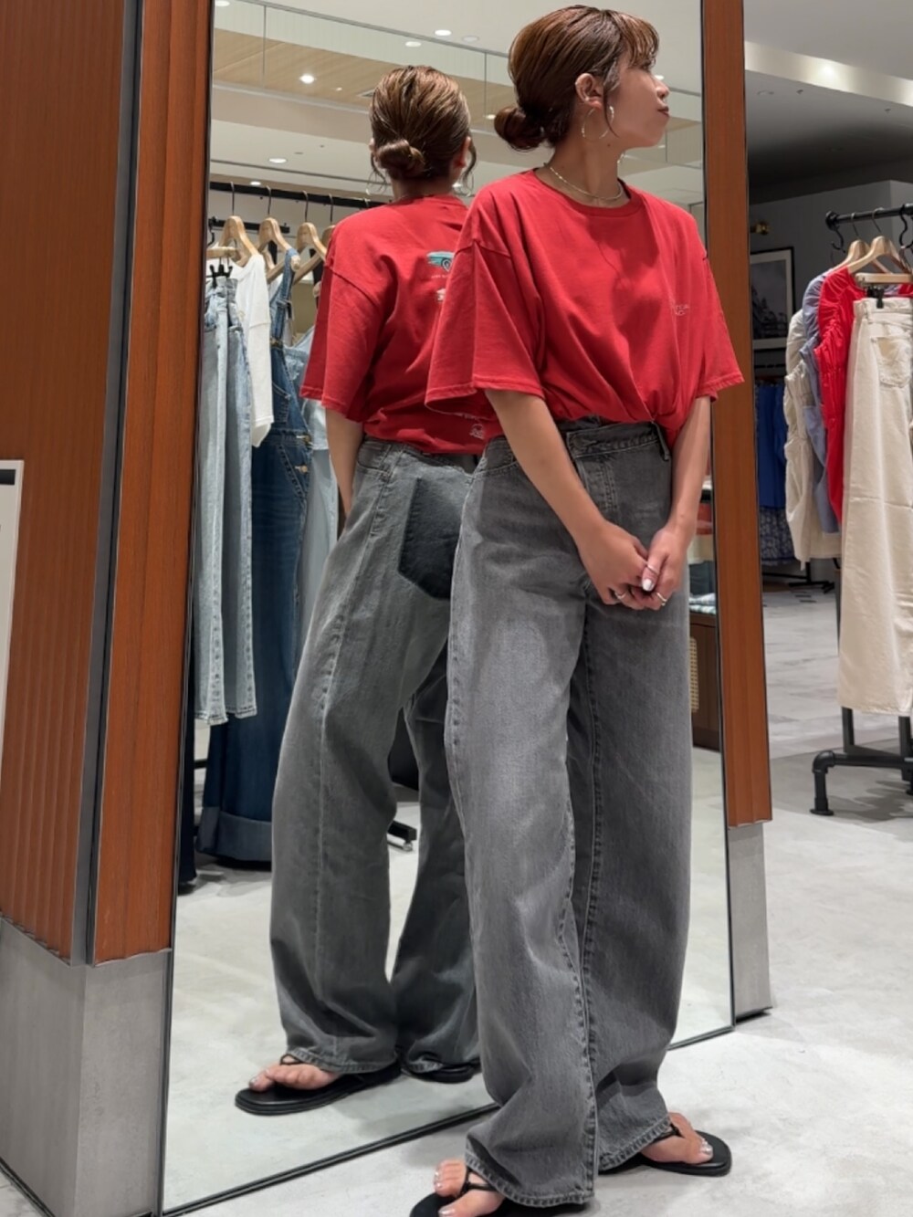 レッド系のTシャツ/カットソー、ブラック系のデニムパンツ、ブラック系のサンダルを着用したレディースの夏コーディネートの2枚目の写真