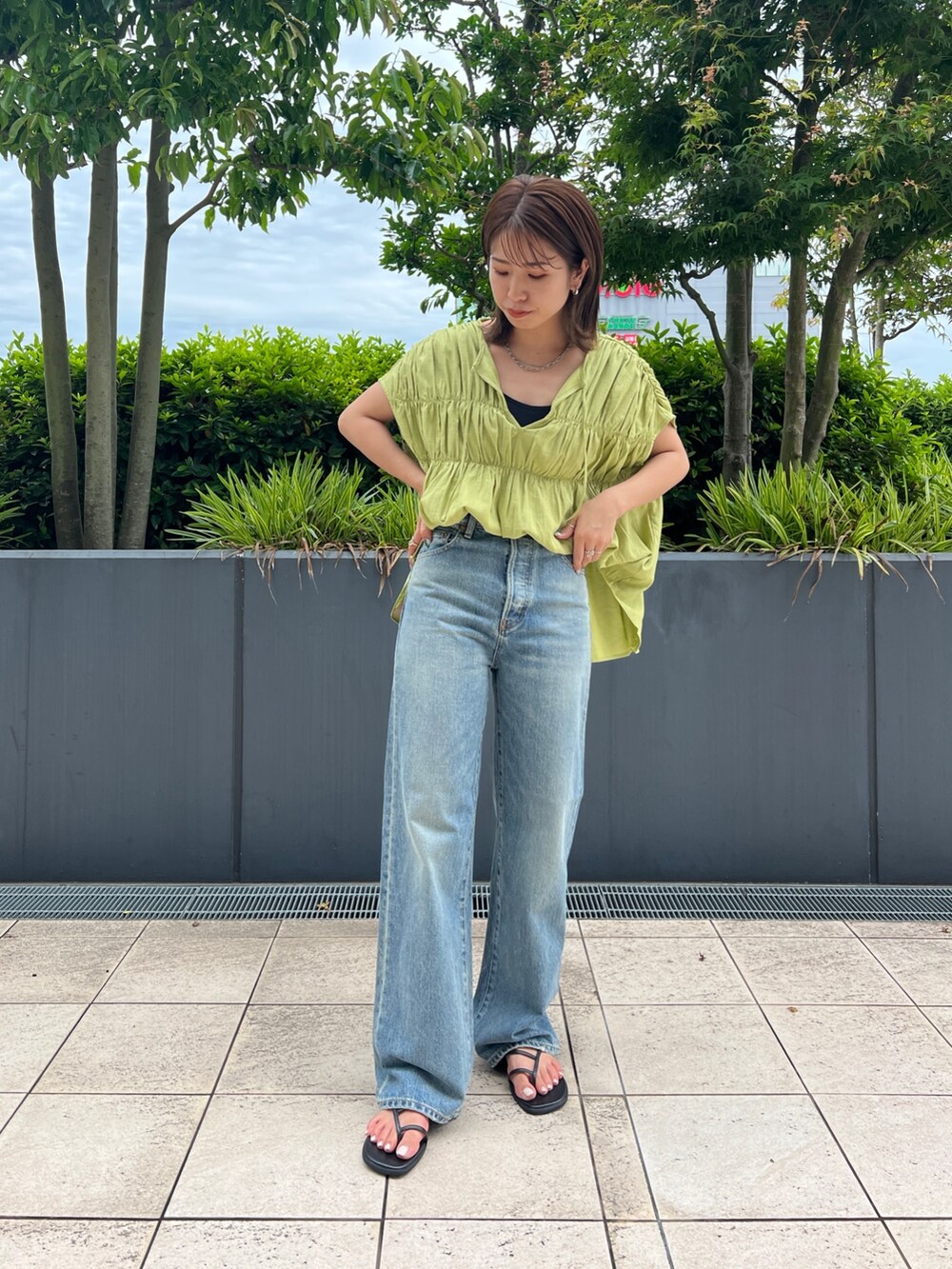 グリーン系のシャツ/ブラウス、ブラック系のキャミソール、ブルー系のデニムパンツを着用したレディースの夏コーディネートの5枚目の写真