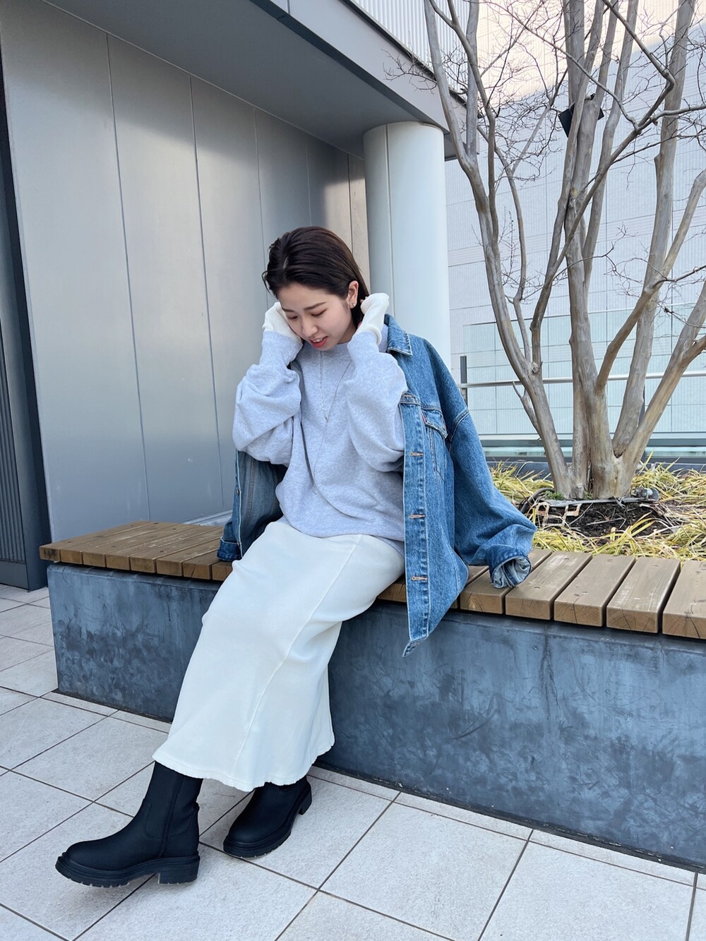 ブルー系のデニムジャケット、グレー系のスウェット、ホワイト系のワンピースを着用したレディースの冬コーディネートの7枚目の写真