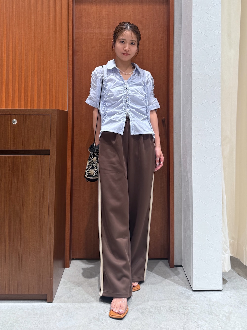 ブラウン系のその他パンツ、ブルー系のシャツ/ブラウス、ブラック系のハンドバッグを着用したレディースの夏コーディネートの5枚目の写真