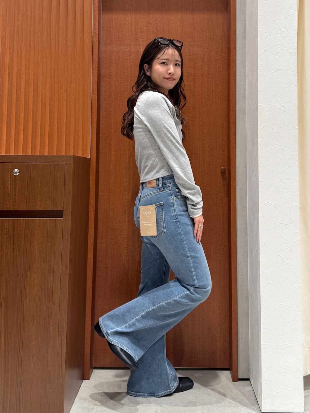 ブルー系のデニムパンツ、ブラック系のサンダル、グレー系のTシャツ/カットソーを着用したレディースの秋コーディネートの5枚目の写真