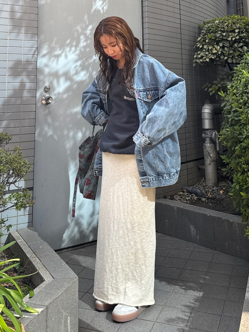 グリーン系のショルダーバッグ、ブルー系のデニムジャケット、グレー系のスウェットを着用したレディースの冬コーディネートの2枚目の写真