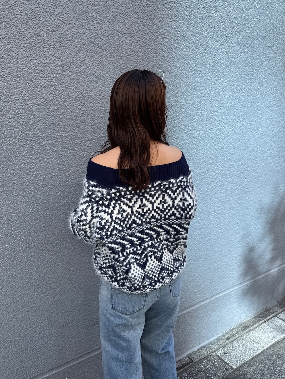 ブルー系のニット/セーター、ブルー系のデニムパンツを着用したレディースの秋コーディネートの10枚目の写真