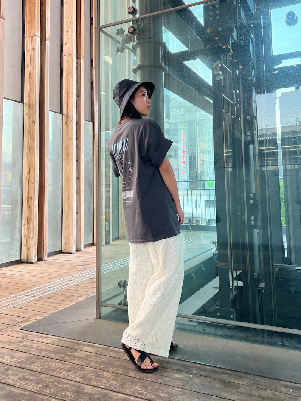 グレー系のTシャツ/カットソー、ホワイト系のその他パンツ、ブラック系のサンダルを着用したレディースの春コーディネートの5枚目の写真