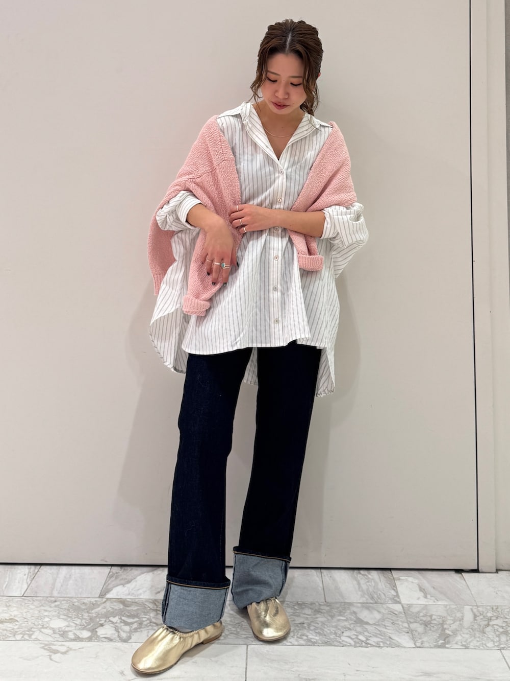 ブルー系のデニムパンツ、ホワイト系のシャツ/ブラウス、ピンク系のニット/セーターを着用したレディースの冬コーディネートの2枚目の写真