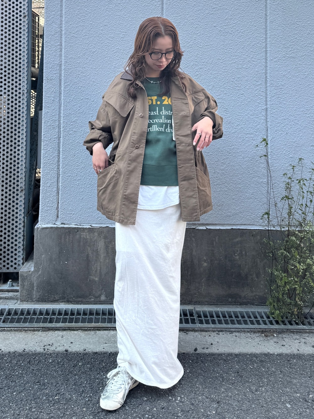 ホワイト系のスカート、ブラウン系のブルゾン、グリーン系のスウェットを着用したレディースの冬コーディネートの2枚目の写真