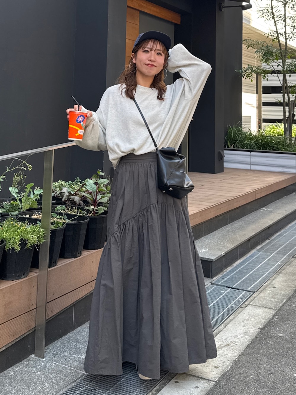 グレー系のスカート、ホワイト系のTシャツ/カットソー、ブルー系のキャップを着用したレディースの夏コーディネートの2枚目の写真