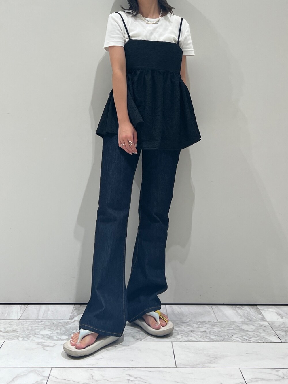 ブルー系のデニムパンツ、ブラック系のキャミソール、ホワイト系のTシャツ/カットソーを着用したレディースの夏コーディネートの7枚目の写真