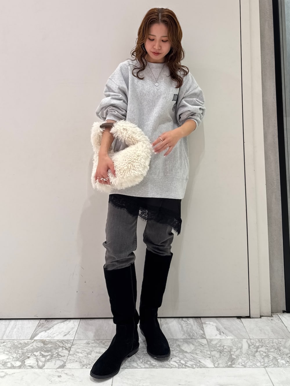 グレー系のスウェット、ブラック系のキャミソール、ブラック系のデニムパンツを着用したレディースの冬コーディネートの3枚目の写真