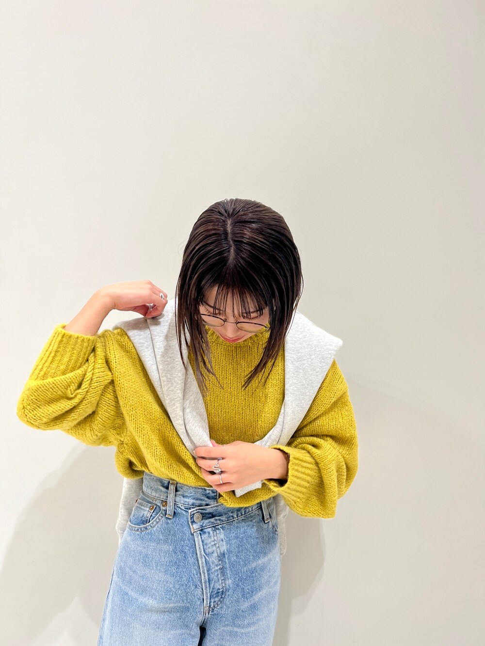 ブルー系のデニムパンツ、イエロー系のニット/セーター、グレー系のスウェットを着用したレディースの冬コーディネートの7枚目の写真