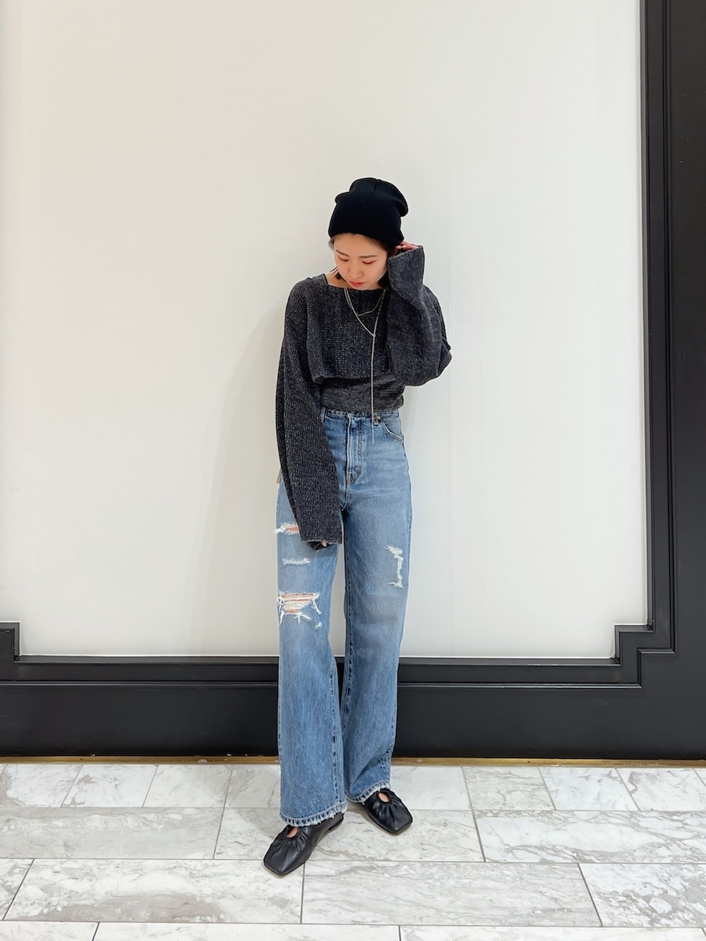 ブルー系のデニムパンツ、グレー系のニット/セーター、ブラック系のパンプスを着用したレディースの春コーディネートの4枚目の写真