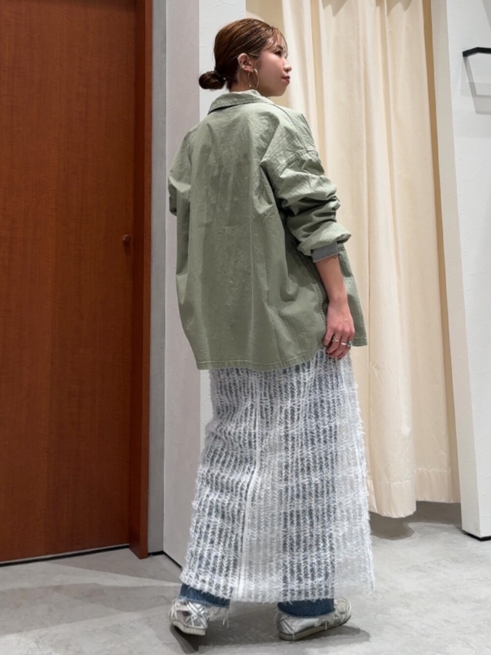 ホワイト系のワンピース、グリーン系のミリタリージャケット、グレー系のTシャツ/カットソーを着用したレディースの春コーディネートの2枚目の写真