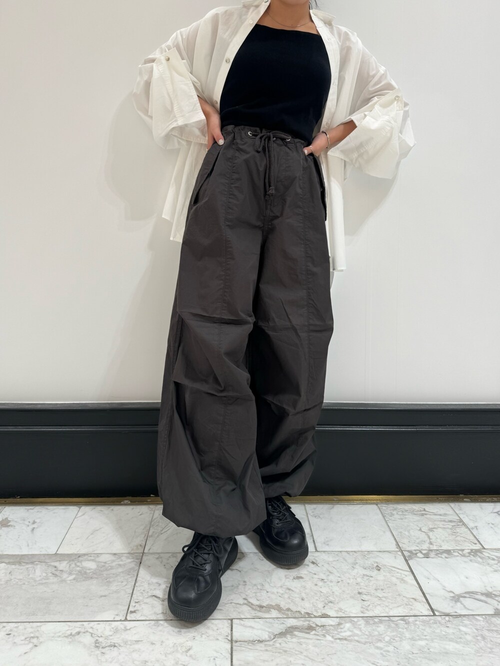 ホワイト系のシャツ/ブラウス、グレー系のその他パンツ、ブラック系のキャミソールを着用したレディースの冬コーディネートの9枚目の写真