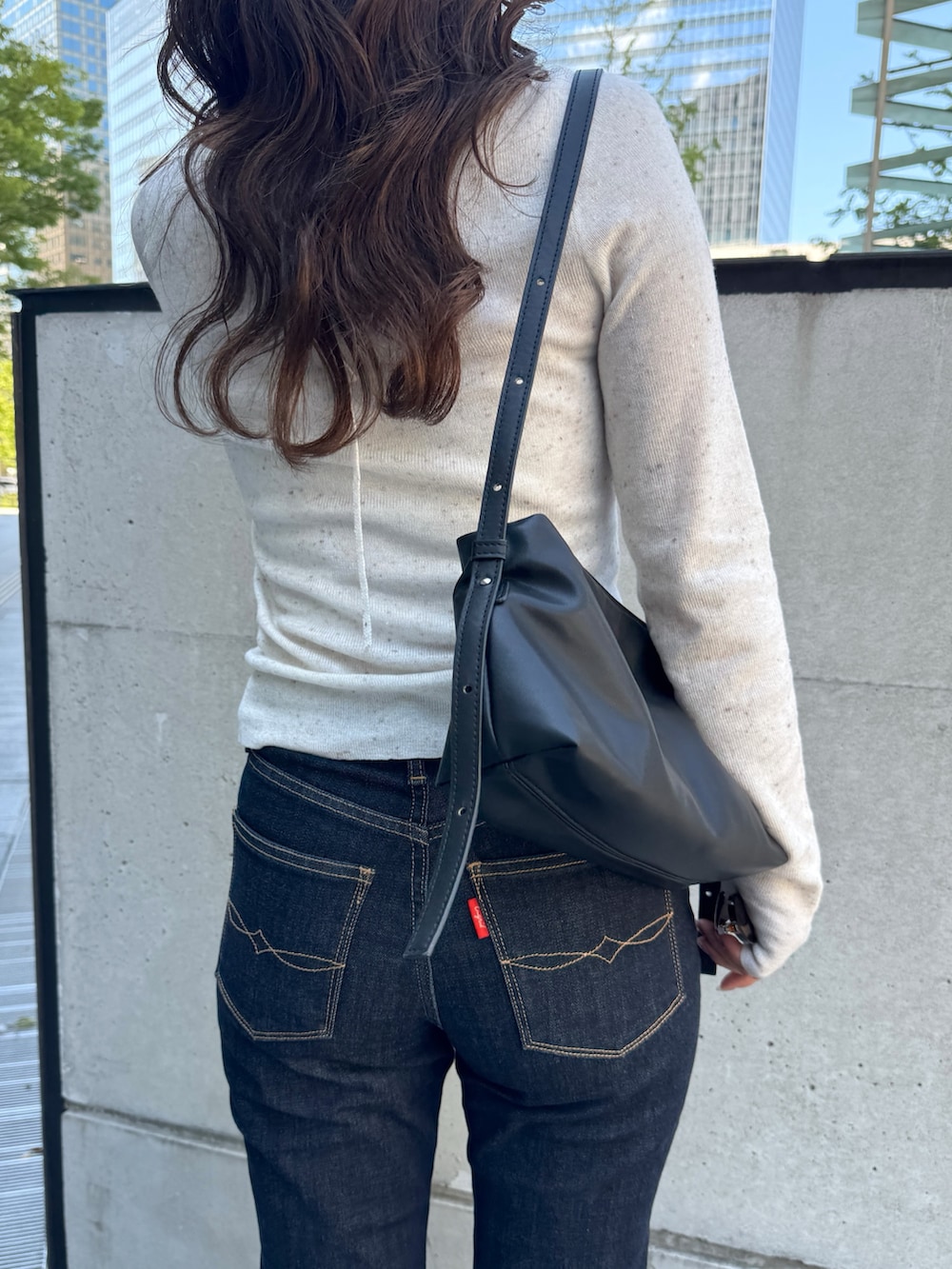 ホワイト系のニット/セーター、ブルー系のデニムパンツ、ブラック系のパンプスを着用したレディースの秋コーディネートの9枚目の写真