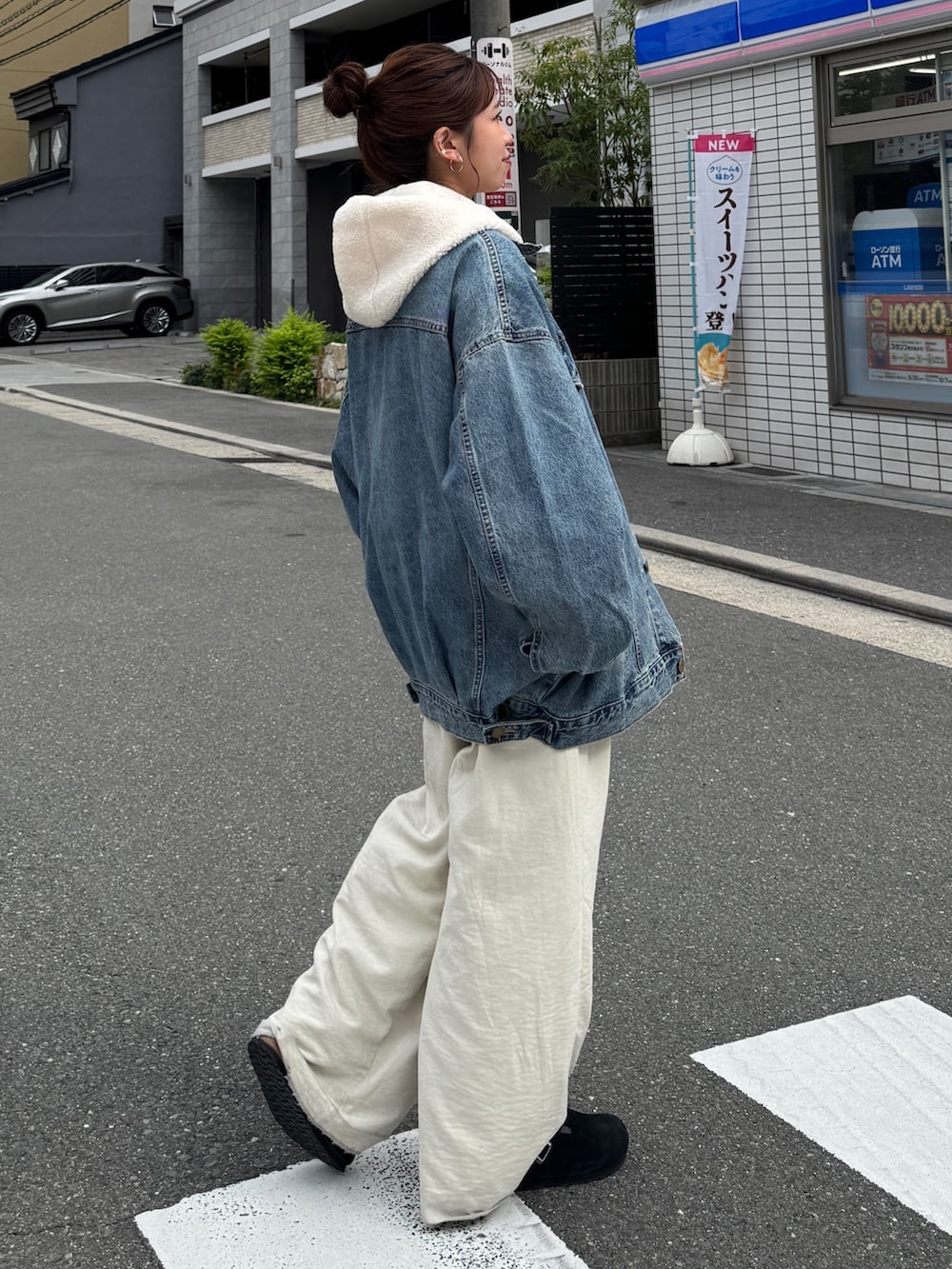 ブルー系のデニムジャケット、ホワイト系のパーカー、ホワイト系のその他パンツを着用したレディースの秋コーディネートの7枚目の写真