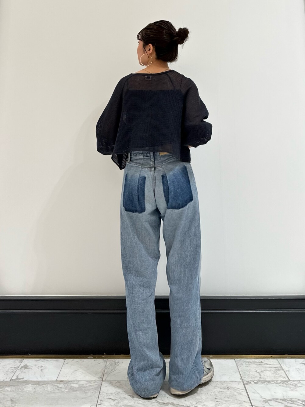 ブラック系のキャミソール、グレー系のTシャツ/カットソー、ブルー系のデニムパンツを着用したレディースの春コーディネートの3枚目の写真