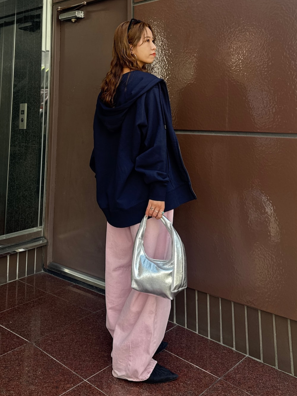 ブルー系のパーカー、ピンク系のデニムパンツ、ブラック系のキャミソールを着用したレディースの春コーディネートの3枚目の写真