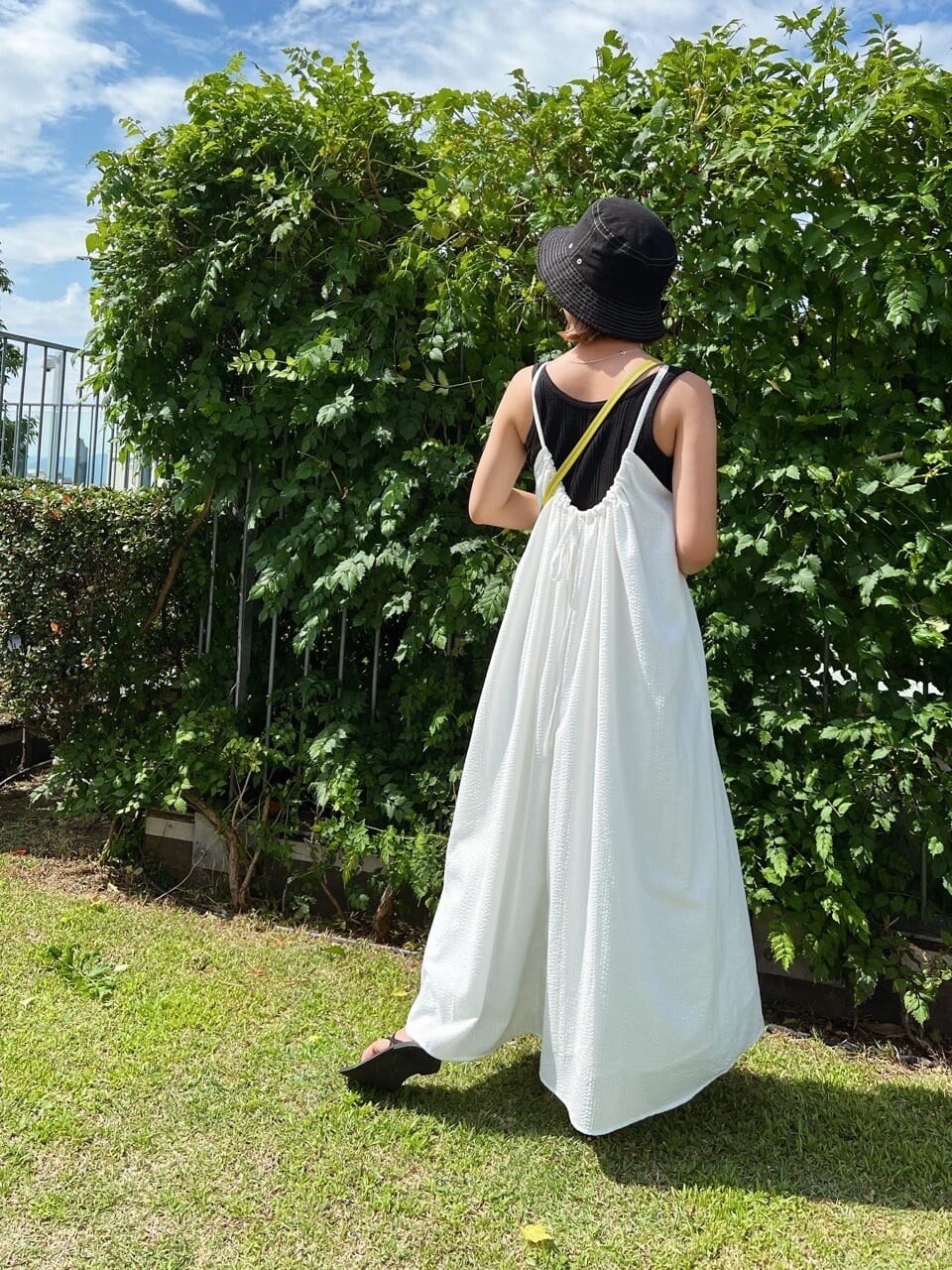 ブラック系のサンダル、ホワイト系のワンピース、ブラック系のタンクトップを着用したレディースの夏コーディネートの2枚目の写真