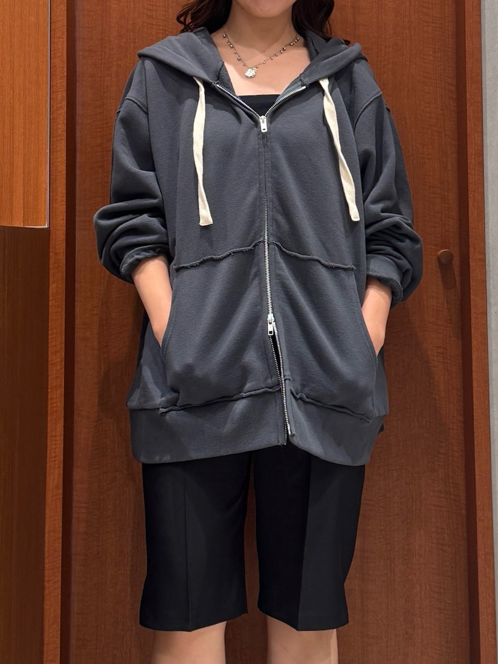 グレー系のパーカー、ブラック系のその他パンツ、ブラック系のその他シューズを着用したレディースの秋コーディネートの6枚目の写真