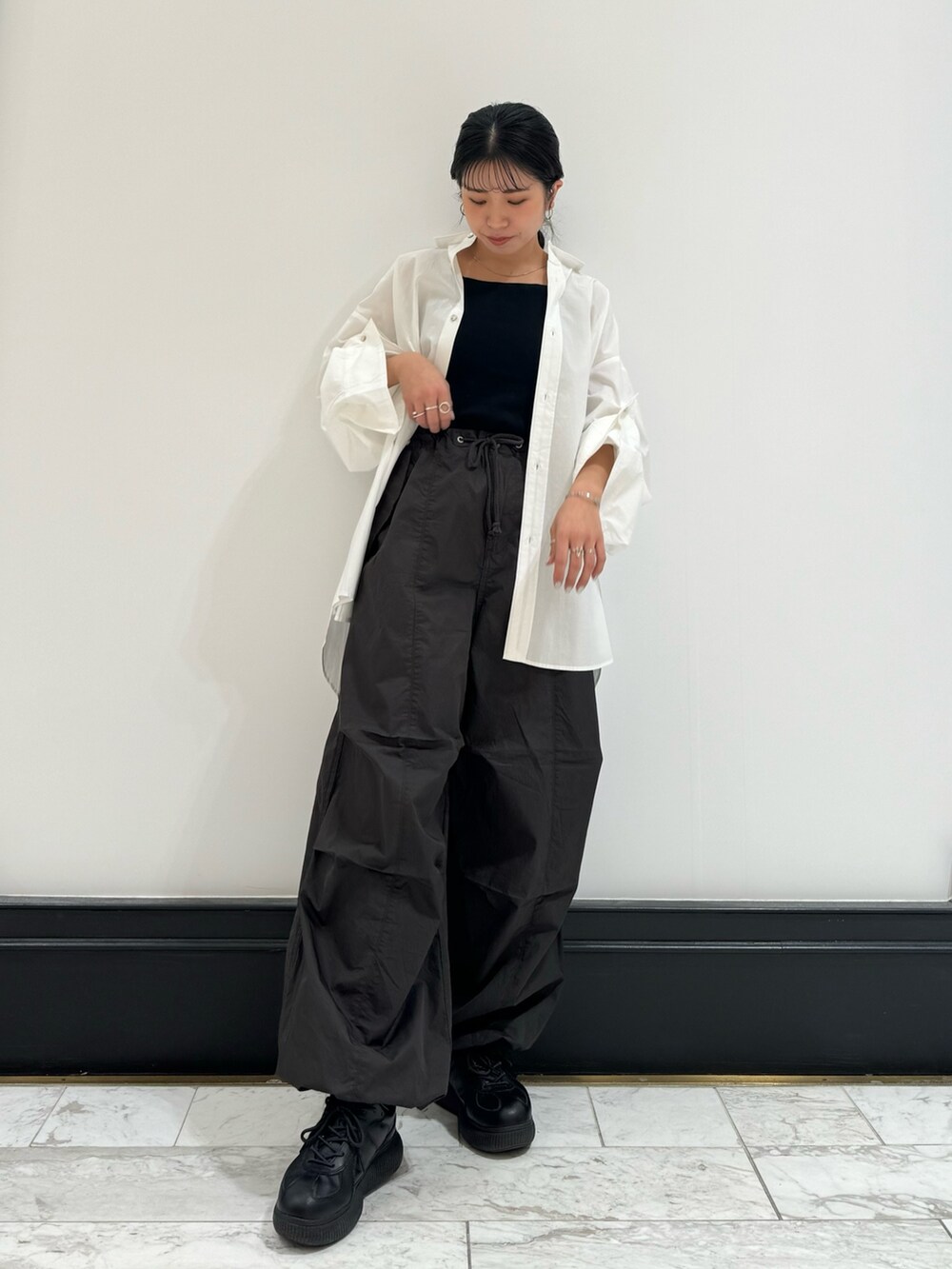 ホワイト系のシャツ/ブラウス、グレー系のその他パンツ、ブラック系のキャミソールを着用したレディースの冬コーディネートの5枚目の写真