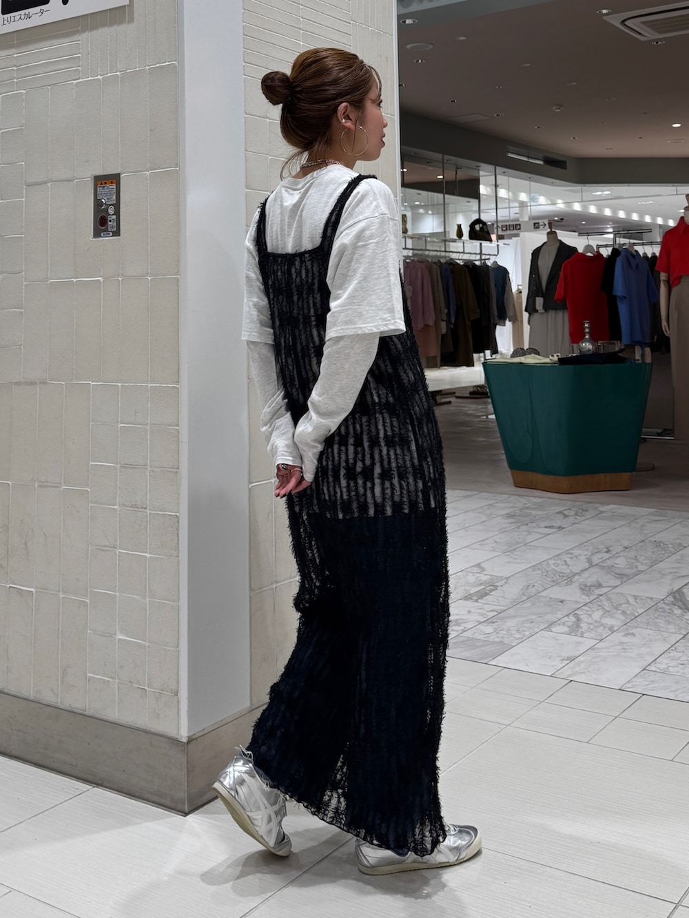 ブラック系のワンピース、グレー系のTシャツ/カットソー、ブルー系のデニムパンツを着用したレディースの春コーディネートの5枚目の写真