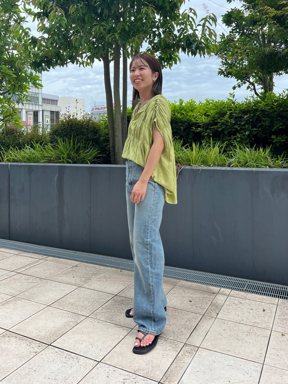 グリーン系のシャツ/ブラウス、ブラック系のキャミソール、ブルー系のデニムパンツを着用したレディースの夏コーディネートの7枚目の写真