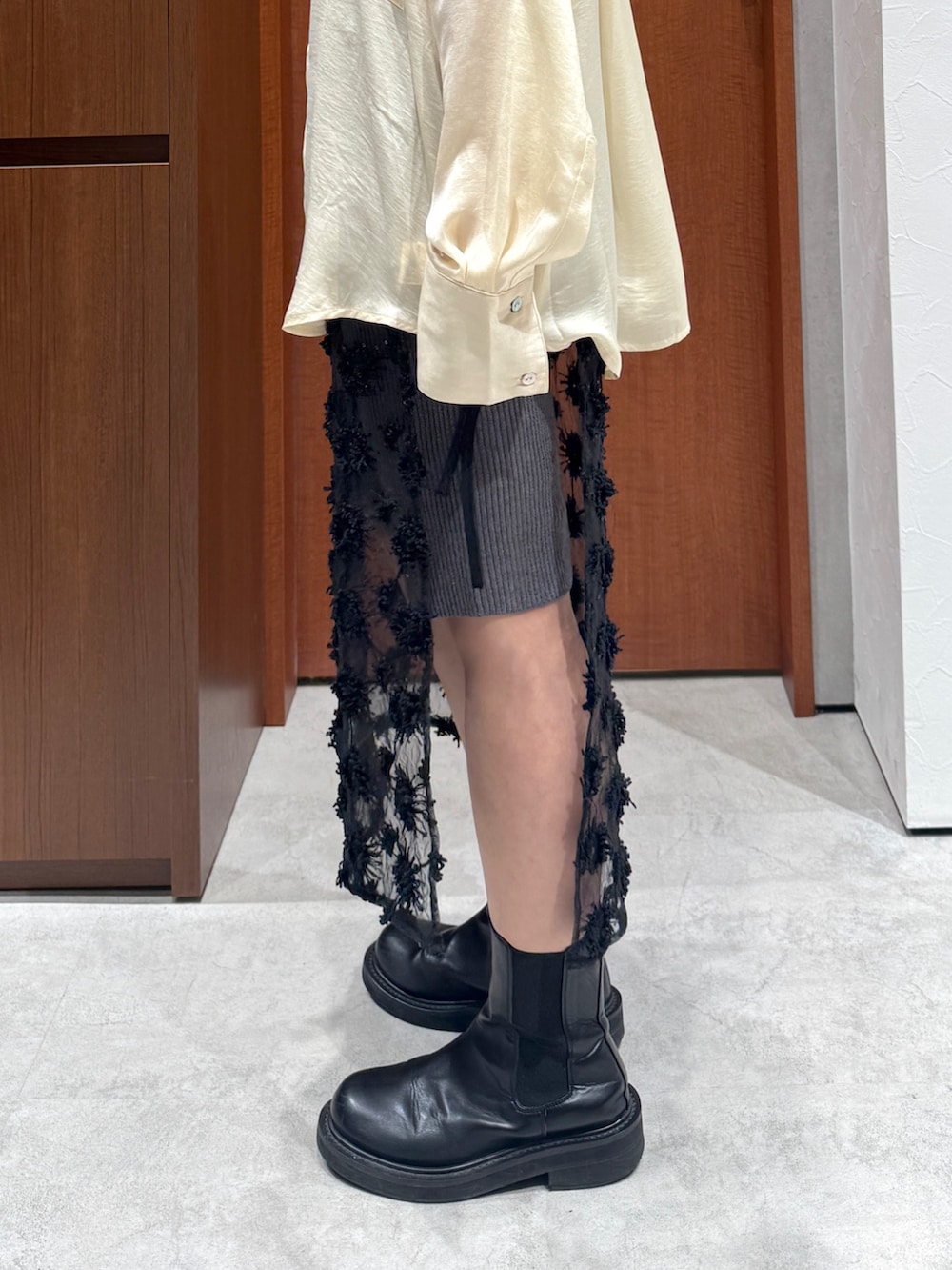 イエロー系のシャツ/ブラウス、グレー系のその他パンツ、ブラック系のスカートを着用したレディースの秋コーディネートの4枚目の写真