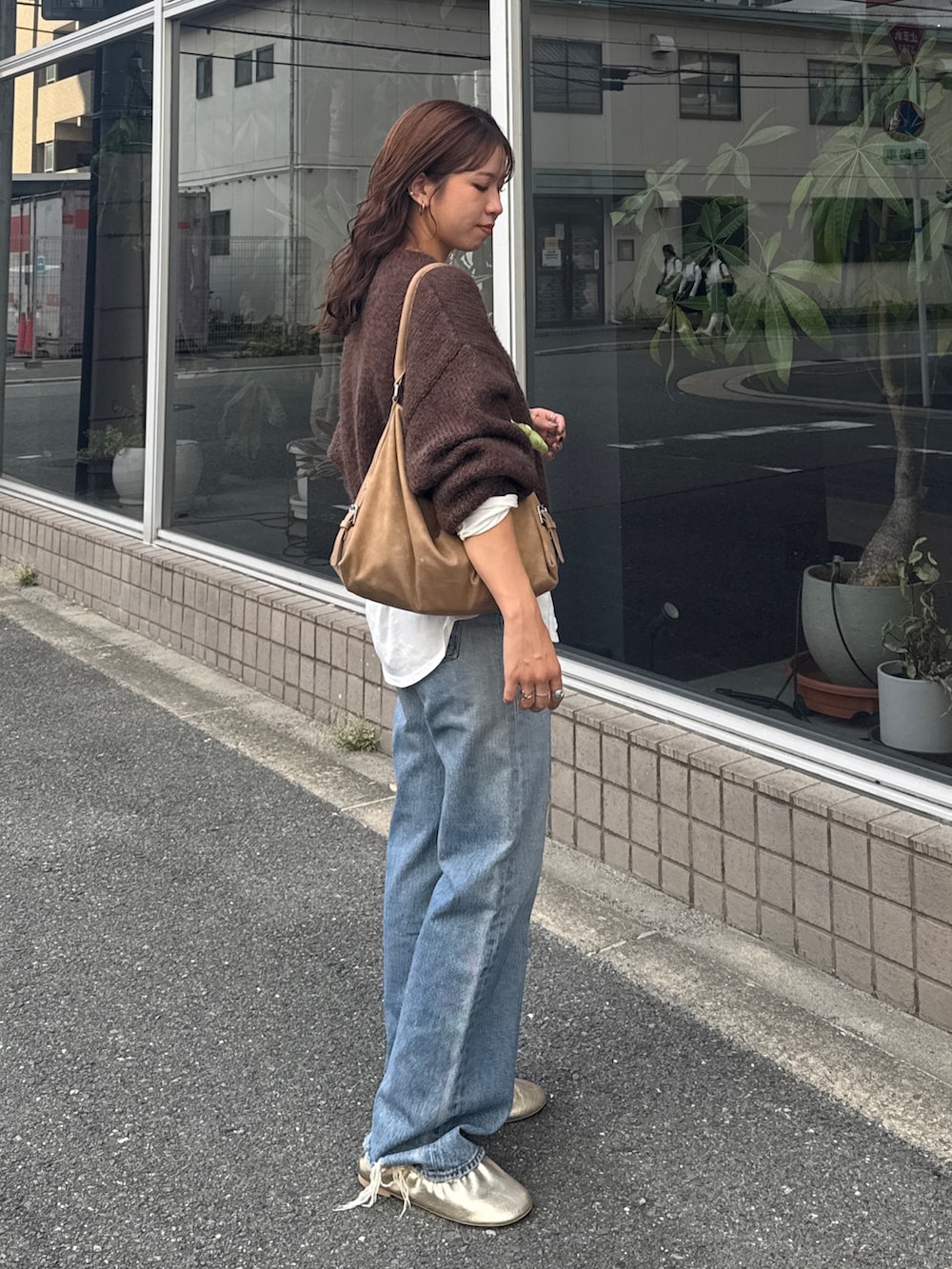 ホワイト系のTシャツ/カットソー、ブラウン系のニット/セーター、ブルー系のデニムパンツを着用したレディースの秋コーディネートの3枚目の写真