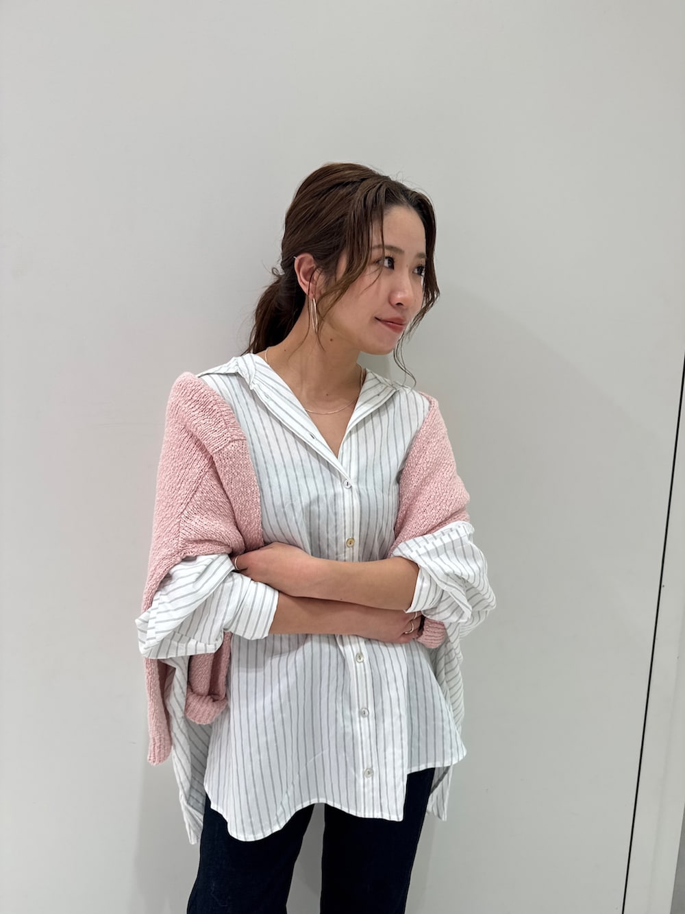 ブルー系のデニムパンツ、ホワイト系のシャツ/ブラウス、ピンク系のニット/セーターを着用したレディースの冬コーディネートの3枚目の写真