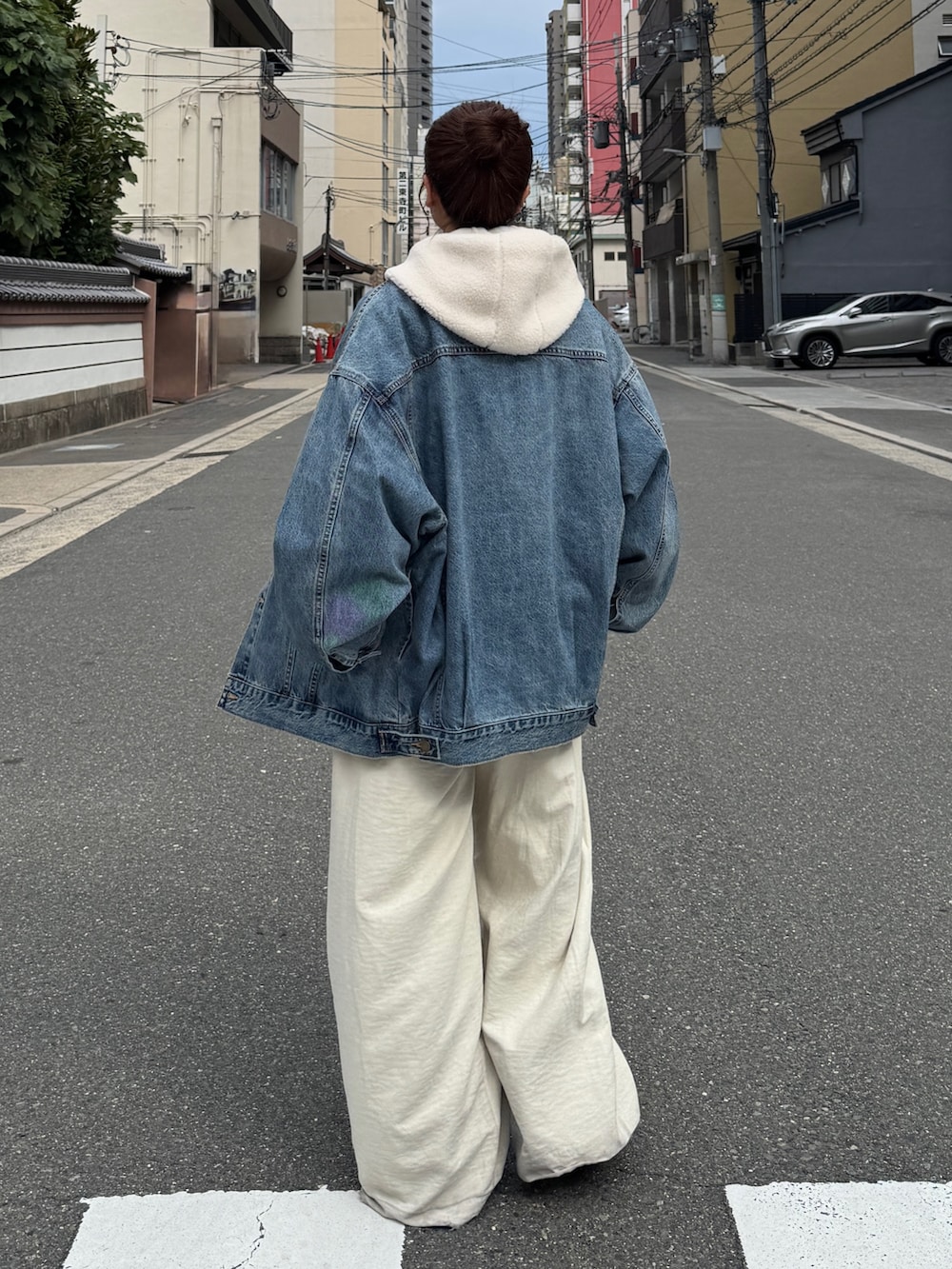 ブルー系のデニムジャケット、ホワイト系のパーカー、ホワイト系のその他パンツを着用したレディースの秋コーディネートの5枚目の写真