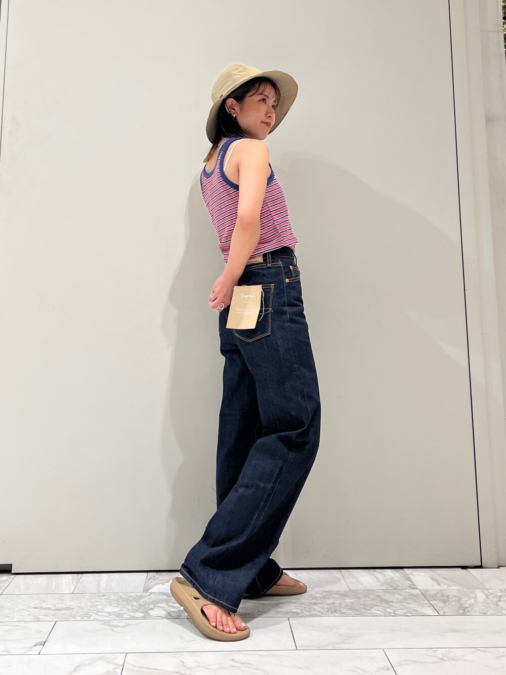 ブルー系のデニムパンツ、ブルー系のタンクトップ、ホワイト系のキャミソールを着用したレディースの夏コーディネートの7枚目の写真