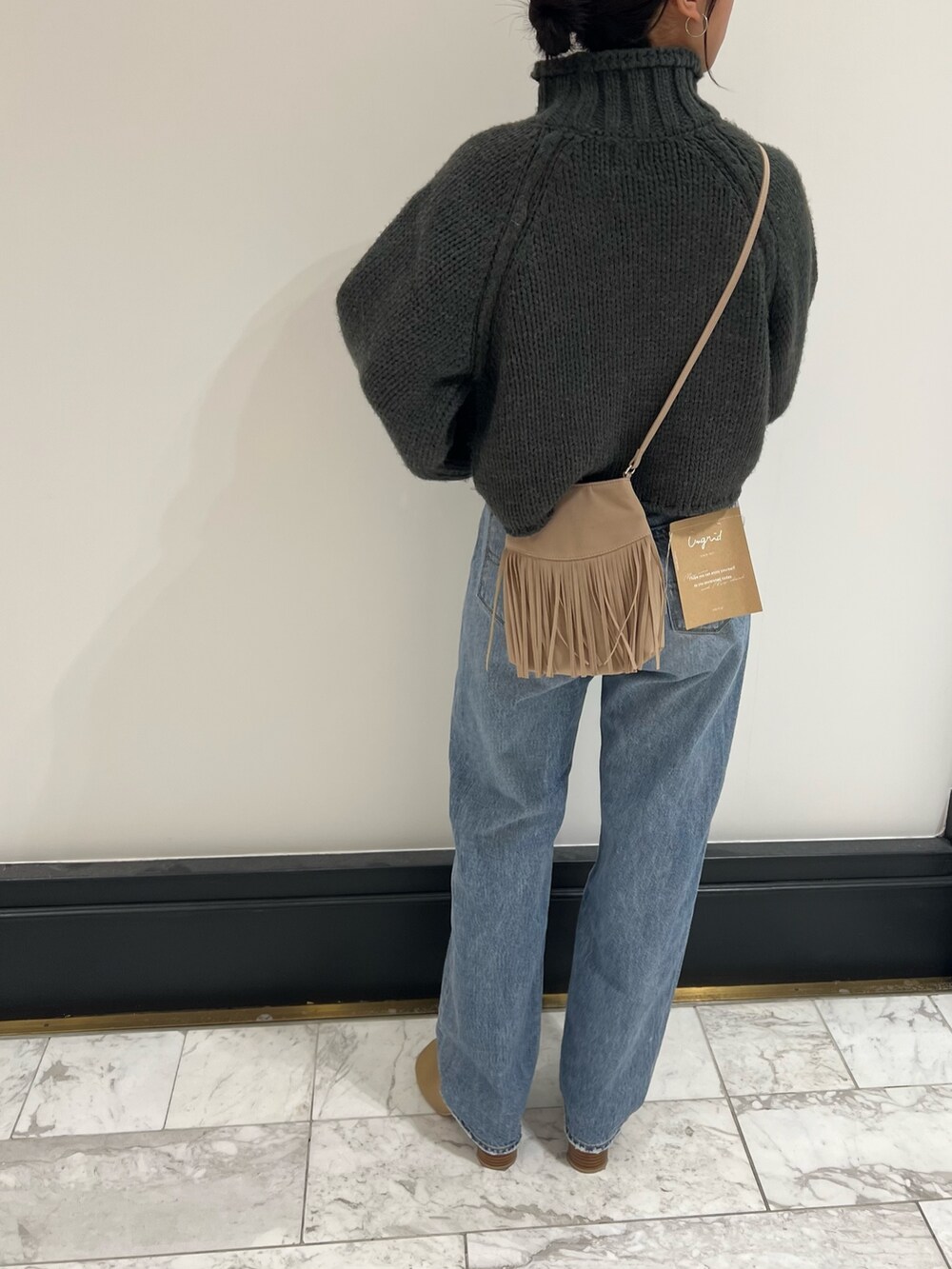 ブルー系のデニムパンツ、グレー系のニット/セーター、ベージュ系のブーツを着用したレディースの秋コーディネートの7枚目の写真