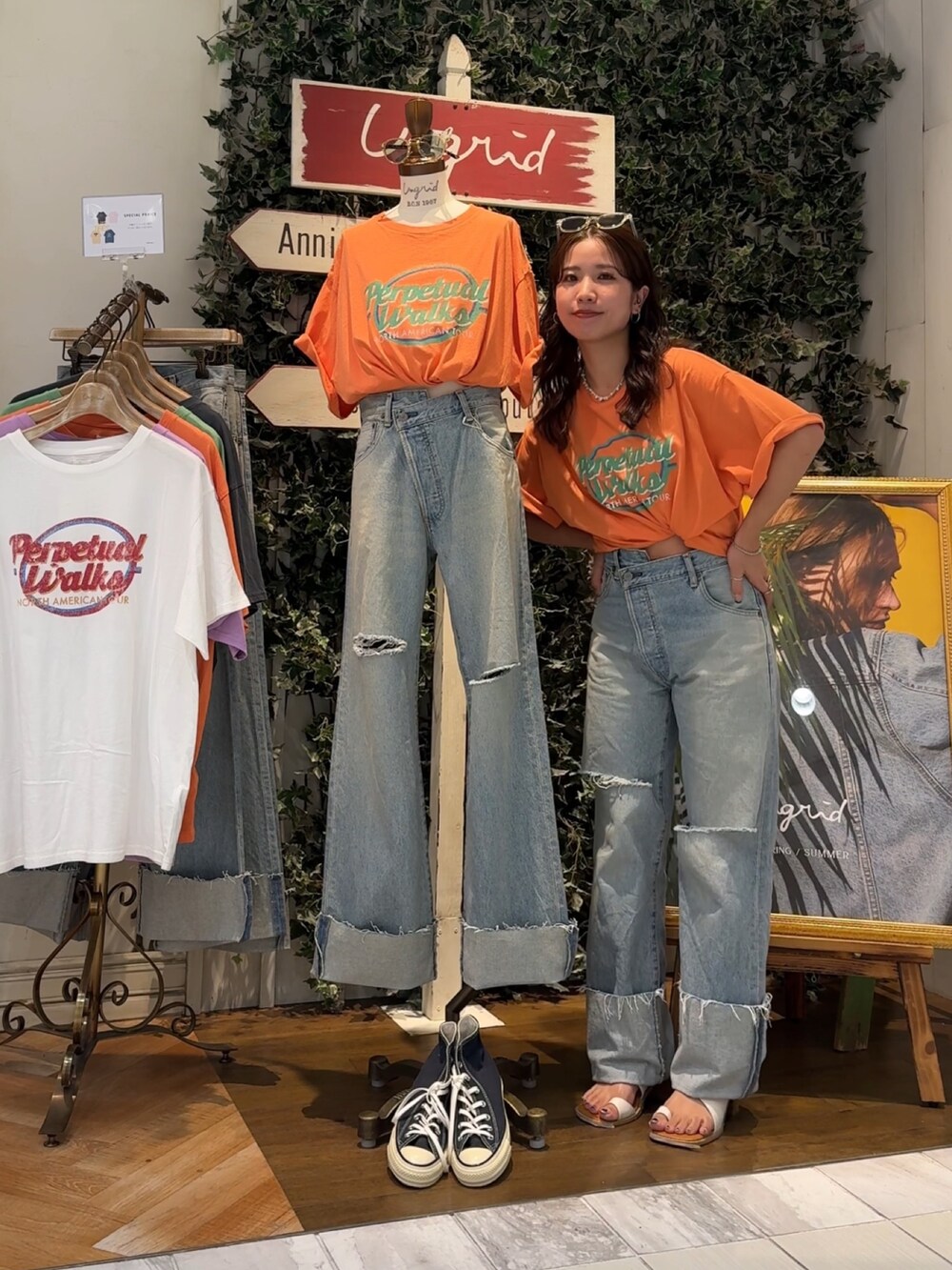 ブルー系のデニムパンツ、オレンジ系のTシャツ/カットソー、ホワイト系のサンダルを着用したレディースの夏コーディネートの6枚目の写真